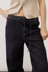 Jean azul oscuro de corte wide leg, con cintura elástica ajustable mediante cordón y bolsillos laterales.