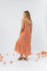 Vestido midi de corte amplio con breteles finos y escote en V. Confeccionado en gasa de algodón con textura, presenta un diseño escalonado con vuelo en el ruedo.