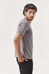 Remera de manga corta color azul grisáceo, con cuello redondo y un pequeño texto bordado en negro en el pecho.
