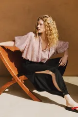 Pantalón bombacho de tiro medio confeccionado en lino, color negro, con pernera abullonada y bajo acabado en puño con botón.