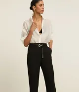 Pantalón de vestir gris oscuro, de corte recto, con bolsillos laterales y traseros. Se ajusta a la cintura con cinturón de cuero marrón.