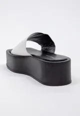 Sandalias negras de plataforma con punta cuadrada y tira ancha sobre el empeine.