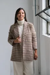 Blazer de corte recto con estampado a cuadros en tonos beige y marrón, con solapas clásicas y cierre frontal.