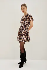 Vestido corto de escote cruzado en V, con mangas cortas tipo kimono y cintura elástica. Presenta un estampado animal print abstracto en tonos marrones, azul oscuro y crema.