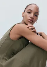 Vestido corto sin mangas de corte evasé, con cuello barco y detalle de pliegues en la falda.