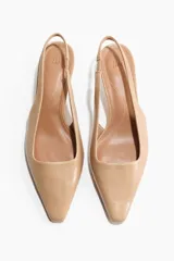 Zapatos destalonados en tejido revestido de color beige, con punta cincelada, tira fina en el talón con elástico y taco kitten.