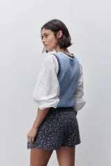 Short cruzado de tiro medio confeccionado en algodón, con diseño que imita una falda en el delantero. Presenta cierre lateral invisible y estampado floral sutil.