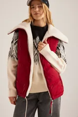 Chaleco puffer rojo con cuello de sherpa color crema, cierre frontal con cremallera y bolsillos laterales.