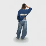 Remera de corte oversize color azul, con estampa gráfica en la espalda que incluye texto y diseño lineal.