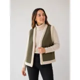 Chaleco estilo gamulán color verde militar con forro y bordes de corderito sintético blanco, diseño sin mangas.