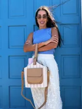 Bolso matero estructurado con diseño a rayas verticales en tonos beige y blanco, cuenta con un bolsillo frontal externo en cuero sintético color tostado, asa de mano corta y correa larga ajustable y desmontable.