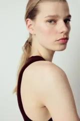 Top de punto color crema, sin mangas, con cuello redondo y corte ajustado.