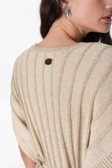 Vestido corto de tejido de punto con rayas verticales en tonos marrón y beige/dorado, con escote en V y tiras finas que se anudan al cuello.