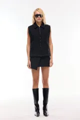 Chaleco negro con cuello solapado y corte oversize.