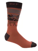 Calcetines de caña media color ladrillo con detalles en marrón oscuro en la puntera, el talón y el borde superior. Presentan un diseño de paisaje montañoso en tonos grises y negros, y un logo de Puma en la parte superior.