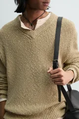 Jersey de punto con calce relajado, cuello pico y manga larga. Tejido en hilatura con textura irregular, mezcla de algodón y lino.