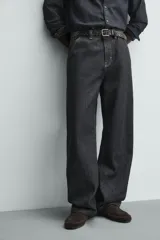 Pantalón chino de denim de algodón rígido, color índigo oscuro sin lavar. Corte baggy fit, tiro medio, con bolsillos frontales y traseros de plastrón. Presenta bordados a contraste en la cintura y en el bolsillo trasero.