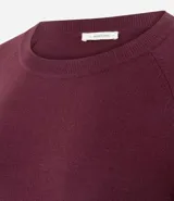 Suéter de punto color marrón chocolate, con cuello redondo y mangas largas con puños acanalados. Presenta un diseño básico y versátil de corte recto.