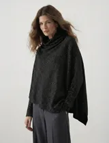 Poncho negro con brillo de lurex, cuello recto, manga japonesa con puños y terminación asimétrica.