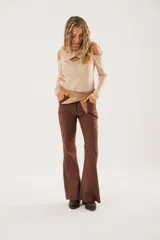 Polera beige de cuello alto con mangas largas y abertura en el pecho.