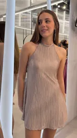Vestido corto de diseño plisado con acabado brillante, escote halter y silueta evasé, confeccionado en tejido ligero.