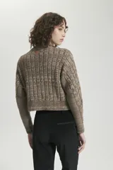 Sweater de tejido de punto con diseño de trenzas y efecto mouliné, cuello redondo y terminaciones en rib en puños y ruedo.
