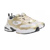 Championes Lacoste modelo Storm 96 2K, con diseño deportivo de estilo retro. Presenta una combinación de malla blanca y paneles superpuestos en tono dorado metalizado, con el logo del cocodrilo en el lateral. Suela robusta con detalles en gris y negro.