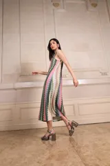 Vestido largo de tejido de punto con estampado de zig-zag vertical en tonos rosados, verdes, beige y lila. Presenta escote en V pronunciado tanto en el frente como en la espalda, con vivos de punto con lurex.