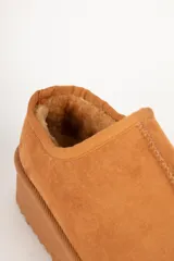 Zueco de gamuza color beige con interior forrado en piel sintética y plataforma de 5 cm de altura.