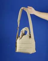 Bandolera azul acolchada con correa ajustable y asa de mano.