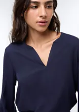 Blusa de viscosa color marrón con escote en V, mangas tres cuartos con puños elásticos y corte holgado.