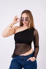 Remera asimétrica de un solo hombro color bordó, con cuerpo opaco y paneles de malla transparente en la cintura y en la manga larga.