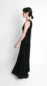 Vestido largo negro evasé de tela ligera y fluida, con escote redondo y sin mangas.
