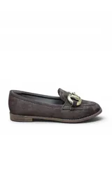 Mocasín de gamuza color marrón, con diseño clásico de punta redonda y detalle de hebilla metálica dorada en el empeine. Cuenta con suela plana y costuras visibles en el borde.