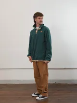 Buzo de pana color beige con cuello polo abotonado y bolsillo en el pecho.