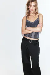 Pantalón cargo de tiro medio confeccionado en tejido satinado. Presenta bolsillos laterales con solapa, corte recto y holgado, y un cinturón integrado del mismo tejido con hebilla metálica.