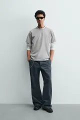 Camiseta de corte boxy fit, con cuello redondo y manga corta. Presenta un acabado irregular con efecto lavado que le otorga un aspecto vintage.