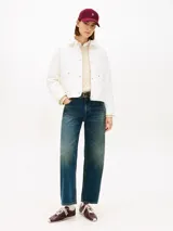 Campera acolchada Tommy Hilfiger de color blanco, confeccionada en poliéster reciclado con diseño matelasse en rombos. Presenta cuello camisero, cierre frontal con cremallera y botones a presión, dos bolsillos frontales de parche con solapa y detalle de logo bordado en el puño.