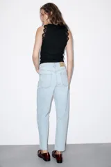 Top negro de punto rib con cuello halter, sin mangas y detalles de encaje a tono en las sisas.