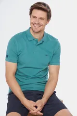 Remera polo de manga corta en tejido piqué color celeste. Presenta cuello clásico con botones, bordado pequeño en el pecho y detalles en tela oxford en el interior del cuello.