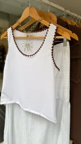 Musculosa de morley verde militar con escote redondo y detalles de bordado artesanal en crochet en los bordes.