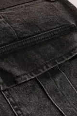 Pantalón jean cargo wide leg color gris oscuro, de tiro medio/bajo con pierna y bota ancha. Tiene cuatro bolsillos grandes en las piernas y largo a los tobillos.