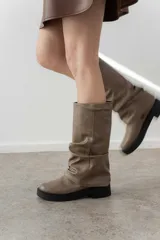 Bota de caña media color negro, confeccionada en cuero sintético con efecto arrugado, suela track y plataforma baja.