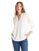 Blusa de color blanco con escote en V y cuello mao. Presenta mangas largas con presilla y botón para regular el largo, y un corte holgado con ruedo redondeado.