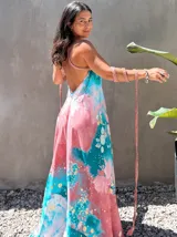 Vestido largo verde con diseño estampado tipo tie-dye y detalles dorados, de corte fluido, un solo hombro y diseño amplio.