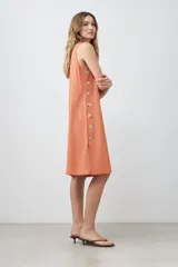 Vestido midi de lino color durazno, corte recto y sin mangas.