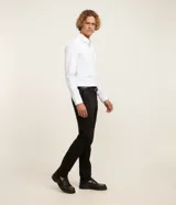 Pantalón slim de sastrería de color gris claro, confeccionado en sarga de algodón con elastano, con cierre frontal de botón y cremallera, y bolsillos.