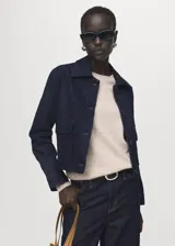 Chaqueta de algodón estilo denim en color azul oscuro, con cuello camisero, bolsillos de parche con solapa en el pecho y cierre frontal con botones.
