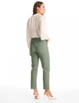 Pantalon de corte slim fit en color verde, confeccionado en tejido tecnico de alta densidad. Presenta una pretina ancha elastizada de estilo pull-on, sin cierres ni botones, y cuenta con cinco bolsillos funcionales.
