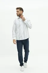 Camisa de manga larga de lino y algodón, color blanco con rayas verticales en tonos gris y beige. Presenta un corte semi slim y un pequeño logo bordado en el pecho.